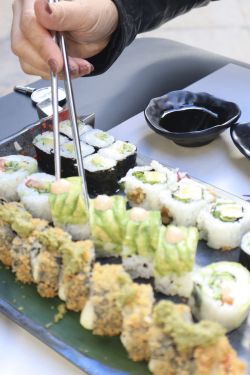 palillos cogiendo una pieza de sushi de una tabla de sushis