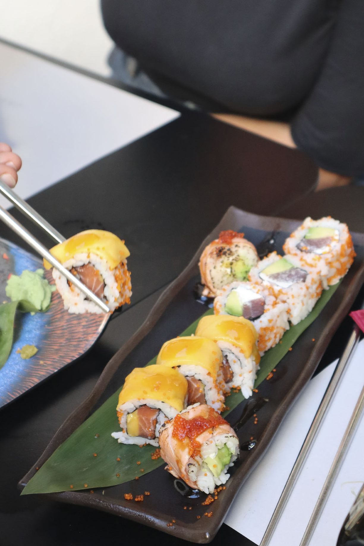 palillos cogiendo un sushi roll